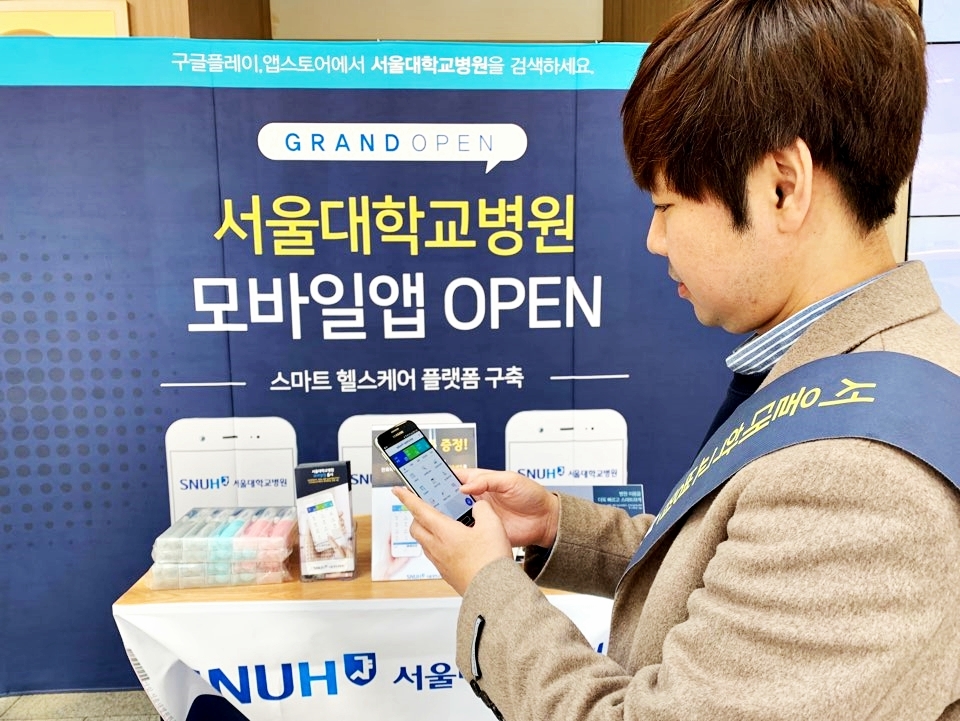 서울대학교병원 본원 1층에 마련된 홍보 부스에서 레몬헬스케어 관계자가 스마트 헬스케어 플랫폼 ‘엠케어’ 기반의 서울대학교병원 모바일 앱을 시연하고 있다. (사진=레몬헬스케어)