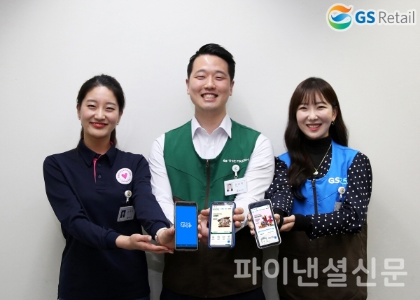 GS리테일 직원들이 THE POP 론칭을 기념하며 휴대폰으로 THE POP 애플리케이션을 실행한 화면을 보이고 있다. (사진=GS리테일)