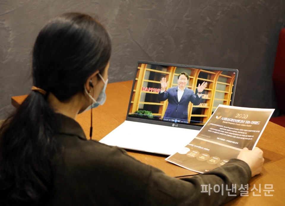 최태원 SK회장(컴퓨터 화면 속)의 사회성과인센티브 어워드 개최 축하 인사를 행사 관계자가 시청하고 있다. (사진=SK제공)