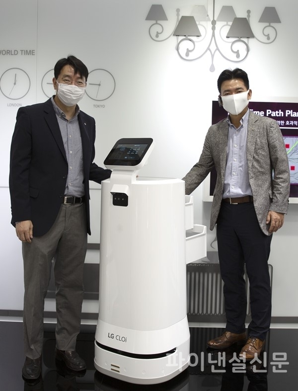 (사진 왼쪽부터) 김성기 GS리테일 상무와 정원진 LG전자 상무가 배달 로봇과 함께 포즈를 취하고 있다. (사진=GS리테일)