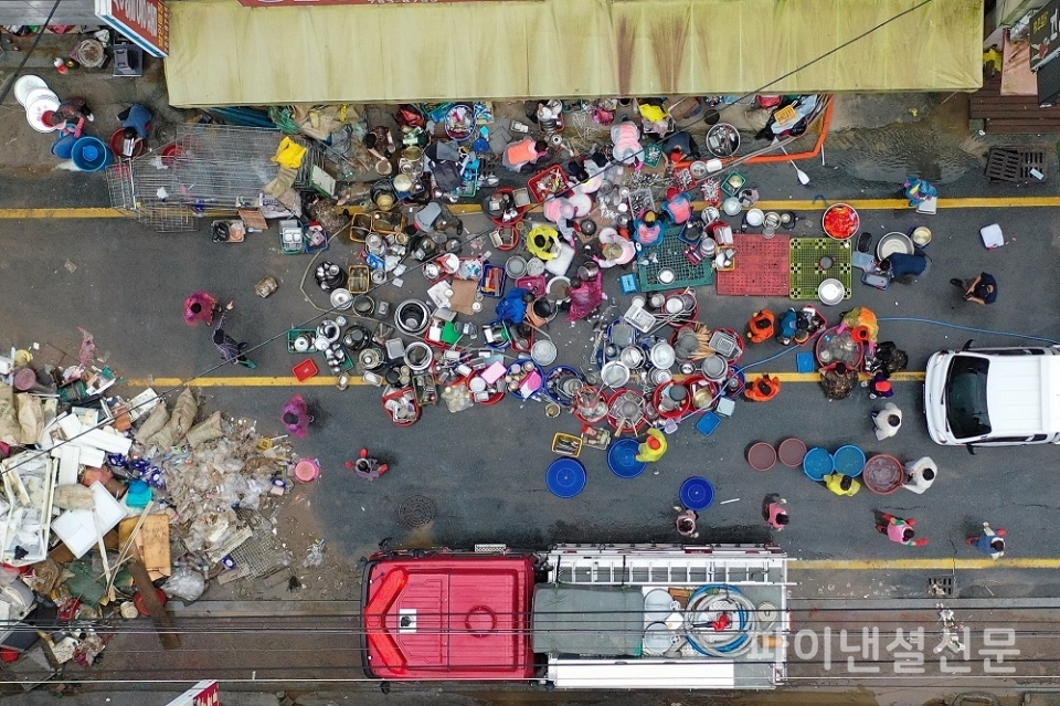 지난 10일 전남 구례군 구례읍 오일장에서 주민이 침수 피해로 진흙 범벅이 된 그릇을 꺼내 씻고 있다./사진=연합