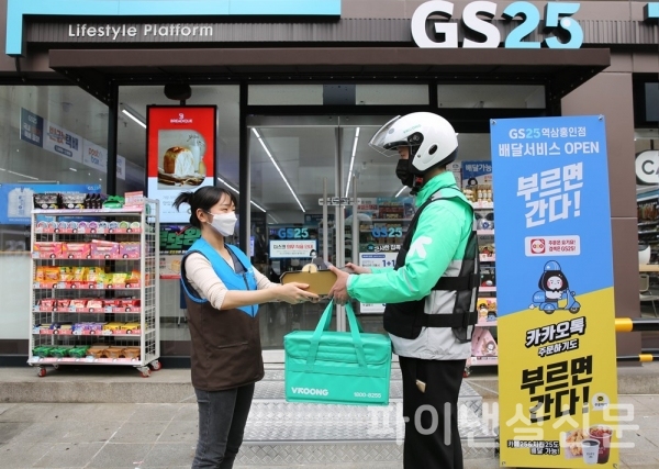 GS25점포앞에서 GS25직원이 부릉 라이더에게 쏜살치킨을 전달하고 있. (사진=GS25)