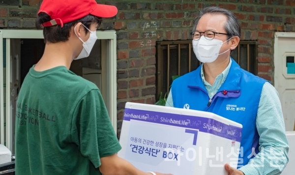 성대규 신한라이프빛나는재단 이사장(사진 오른쪽)이 지난 4일 서울 용산구 아동들에게 건강식단이 담긴 상자를 전달하고 있다. (사진=신한라이프)