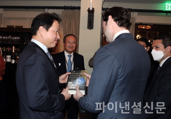 최태원 SK회장이 6일 미국 워싱턴D.C. 인근에서 열린 '2021 트랜스 퍼시픽 다이얼로그'에서 존 오소프 상원의원(조지아주)에게 책을 선물받으며 환담을 나누고 있다.(사진=SK)