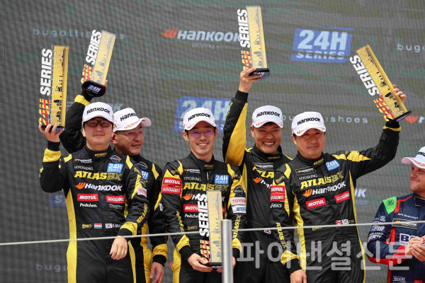 한국타이어가 후원하는 레이싱팀 '한국 아트라스BX 모터스포츠' 선수들이 '2022 한국 24시 바르셀로나'의 'GT4 클래스'에서 우승을 차지하고 포디움에서 우승컵을 들어올리고 있다. (사진=한국타이어)