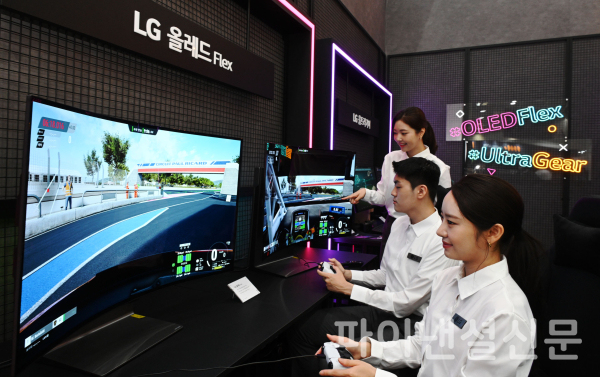 LG전자 모델들이 4일부터 나흘간 서울 삼성동 코엑스에서 열리는 한국전자전(KES 2022)에서 벤더블(Bendable) 게이밍 올레드 TV 플렉스(FLEX)로 게임을 즐기고 있다. (사진=LG전자)