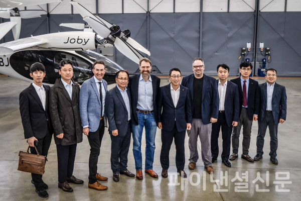 미국 새너제이에 위치한 조비 에비에이션 생산시설에서 유영상 SK텔레콤 CEO(오른쪽에서 다섯번째)와 조벤 비버트 조비 에비에이션 CEO(오른쪽에서 여섯번째)를 비롯한 양사 주요 경영진이 UAM 항공기 앞에서 기념촬영을 하는 모습 (사진=SKT)