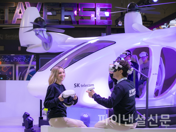SKT 전시관에서 현지 모델들이 조비 에비에이션의 기체를 기반으로 제작한 실물 크기의 UAM 모형을 소개하고 있는 모습. (사진=SKT)