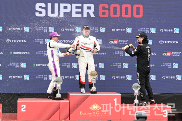 2023 CJ대한통운 슈퍼레이스 챔피언십 2라운드 슈퍼 6000 클래스 결승 후 포디움에서 정의철(왼쪽)과 황진우(오른쪽)으로부터 우승을 축하하는 샴페인 세례를 받는 이찬준(가운데) (사진=황병우 기자)