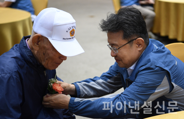 포스코이앤씨 한성희 사장이 6.25 참전 어르신께 꽃을 달아 드리고 있다. (사진=포스코이앤씨)