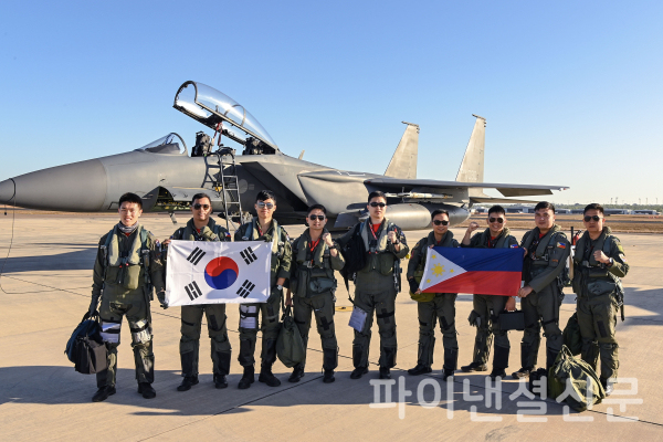 한국 공군과 필리핀 공군 조종사들이 우정비행에 앞서 F-15K 앞에서 양국 국기를 들고 기념촬영을 하고 있다. (사진=공군)