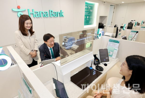 이승열 하나은행장(사진 가운데)이 19일 경기도 평택시 평택동 소재 외국인 특화 점포 '평택외국인센터점' 내 실시간 다국어 통번역 시스템이 설치된 창구에 앉아 외국인 고객을 응대하고 있다. (사진=하나은행)