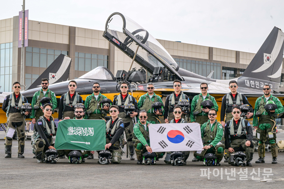 지난 2월 7일 진행된 '블랙이글스-사우디 호크스(Saudi Hawks) 지상교류 행사'에서 블랙이글스 조종사들과 사우디 호크스 조종사들이 T-50B 항공기 앞에서 양국 국기를 들고 함께 기념촬영을 하고 있는 모습. (사진=공군)
