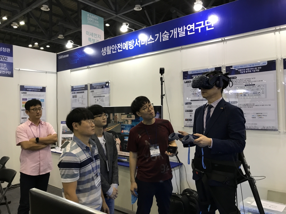 ETRI 권승준 선임연구원이 VR 헤드셋을 쓰고 화재시 소화기 사용 방법을 체험할 수 있도록 설명하는 모습 (사진=ETRI)