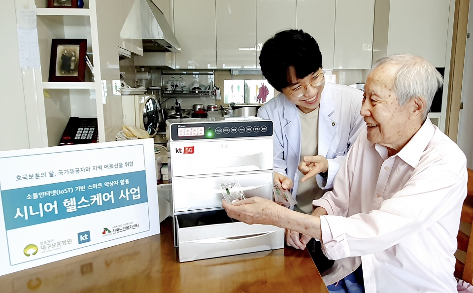 대구 보훈병원 방문간호사가 국가유공자 김갑생 씨의 자택에서 스마트 약상자를 이용해 복약 지도를 하고 있다. (사진=KT)